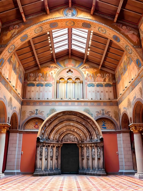 Interior of the Museum of Fine Arts in Budapest, featuring ornate arches and detailed frescoes.