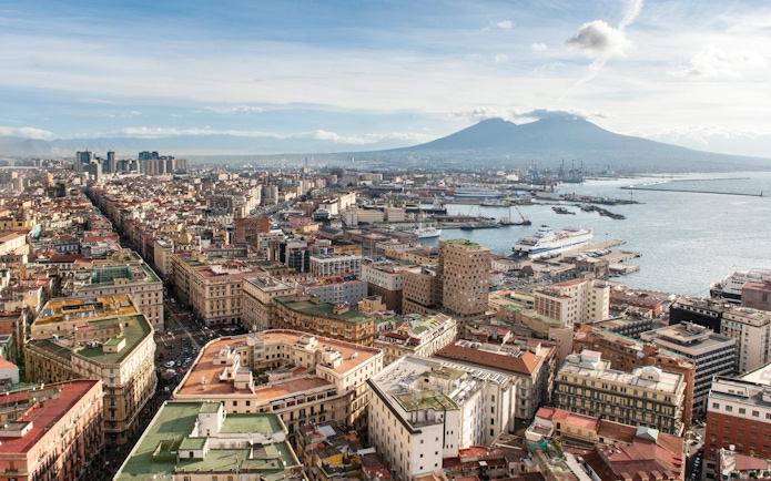 Aerial view of Naples with Mount Vesuvius in the background, near train transfer to Herculaneum.