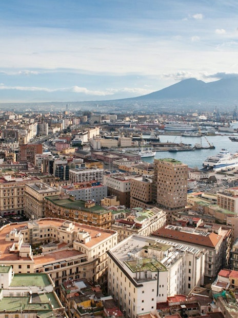 Aerial view of Naples with Mount Vesuvius in the background, near train transfer to Herculaneum.