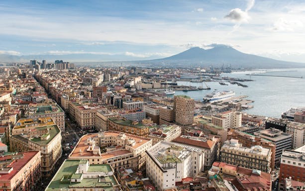 Aerial view of Naples with Mount Vesuvius in the background, near train transfer to Herculaneum.