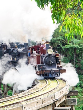 Steam train crossing a trestle bridge on the Puffing Billy Railway, Melbourne.