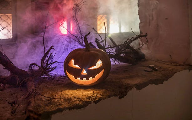 Jack-o'-lantern with glowing eyes at Bran Dracula's Castle Halloween tour.