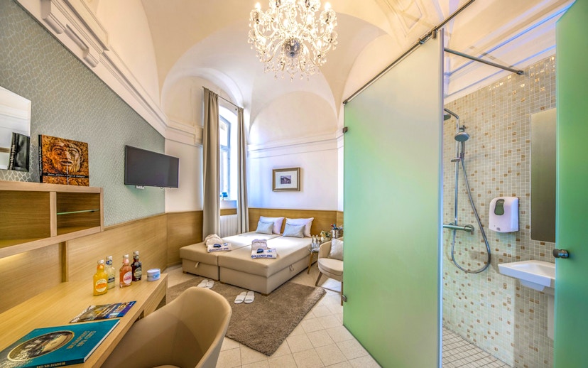 Private cabin interior at Premium Day Spa, Szechenyi Bath, with bed and shower area.