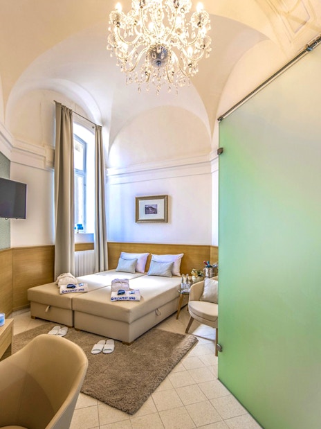 Private cabin interior at Premium Day Spa, Szechenyi Bath, with bed and shower area.