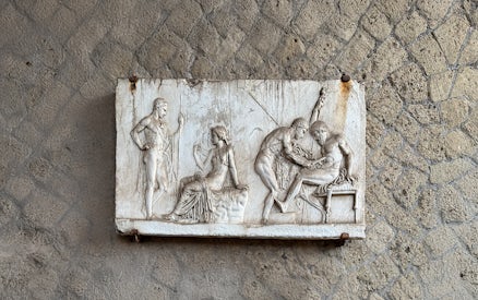 Ancient relief sculpture depicting figures in Herculaneum archives.