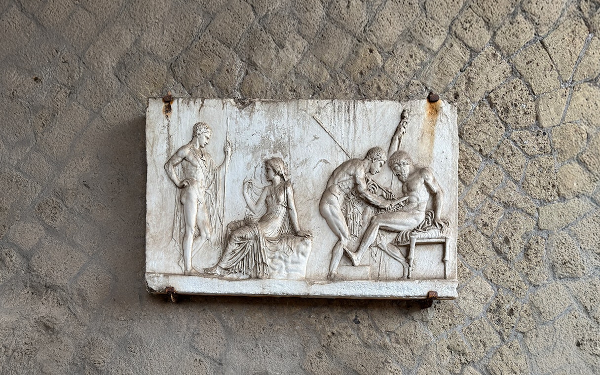 Ancient relief sculpture depicting figures in Herculaneum archives.