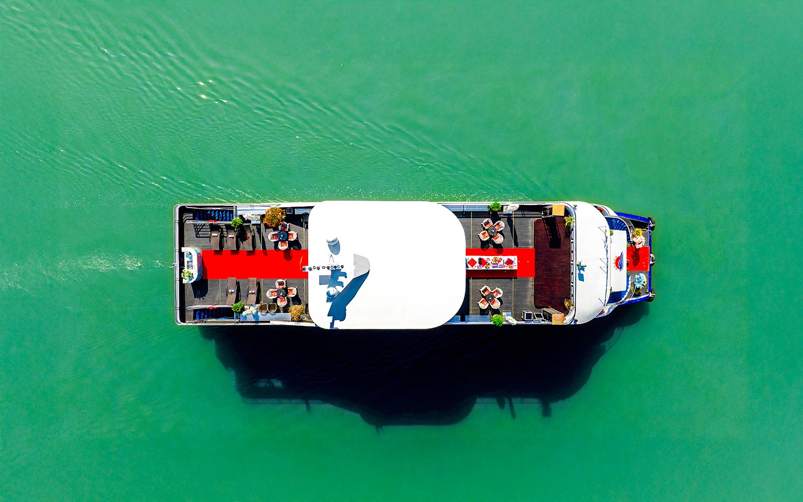 Aerial view of a boat with a red carpet and seating on the Deck of Harmony.