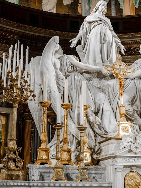 Statues and ornate altar inside The Church of St Madeleine, Paris, France.