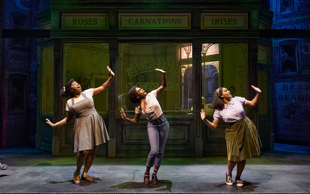 Performers dancing in front of Mushnik's flower shop in "Little Shop of Horrors" stage production.