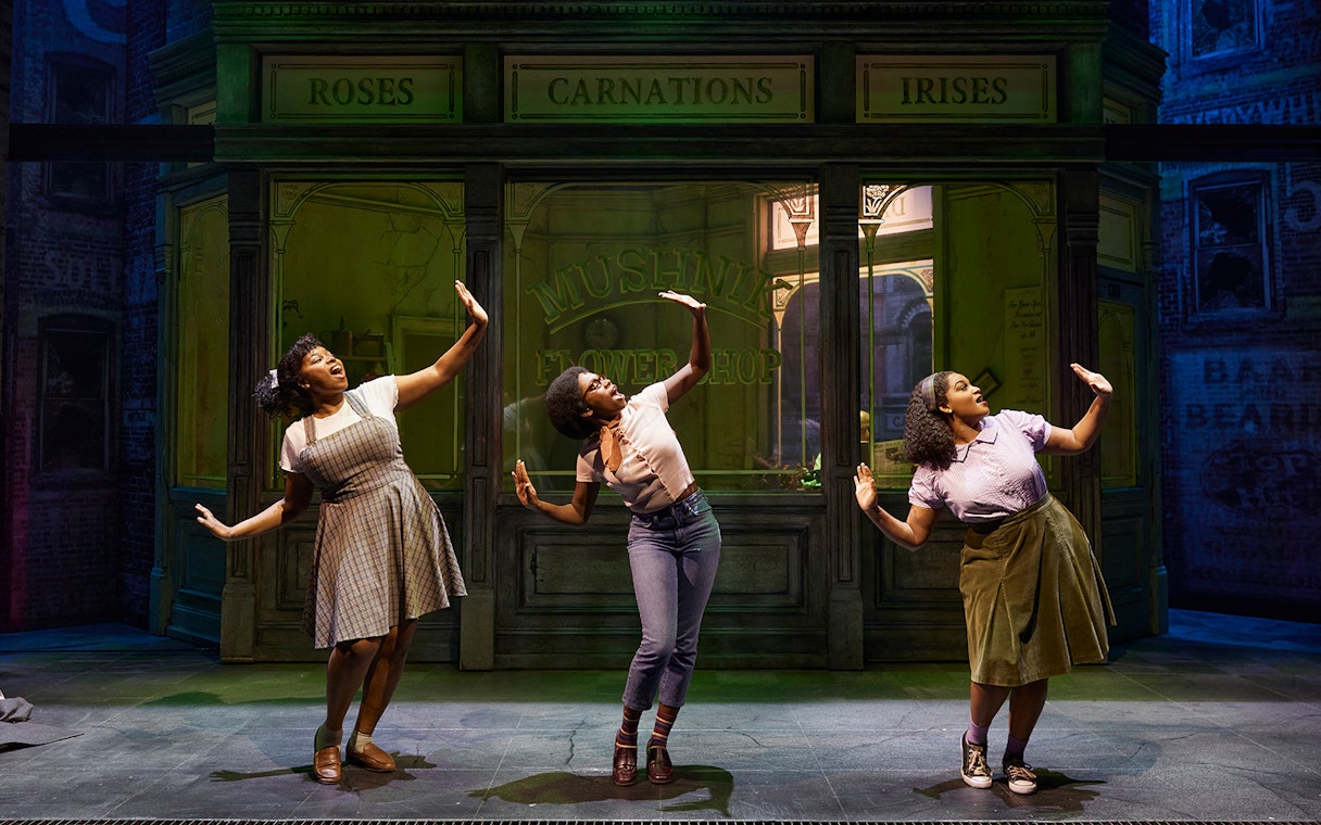 Performers dancing in front of Mushnik's flower shop in "Little Shop of Horrors" stage production.