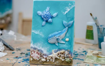 Artwork creation with ocean theme featuring a turtle and whale in Hanoi workshop.