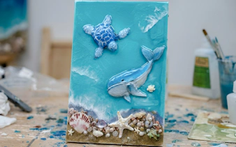 Artwork creation with ocean theme featuring a turtle and whale in Hanoi workshop.