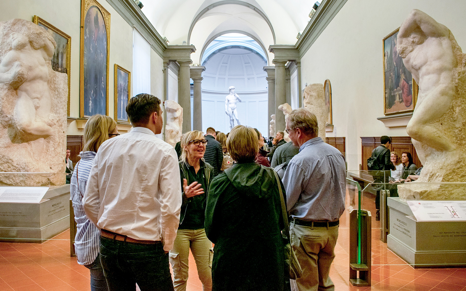 Tour guide leading tourists through Accademia Gallery, Florence, Italy, during skip-the-line tour.