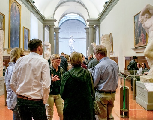 Tour guide leading tourists through Accademia Gallery, Florence, Italy, during skip-the-line tour.