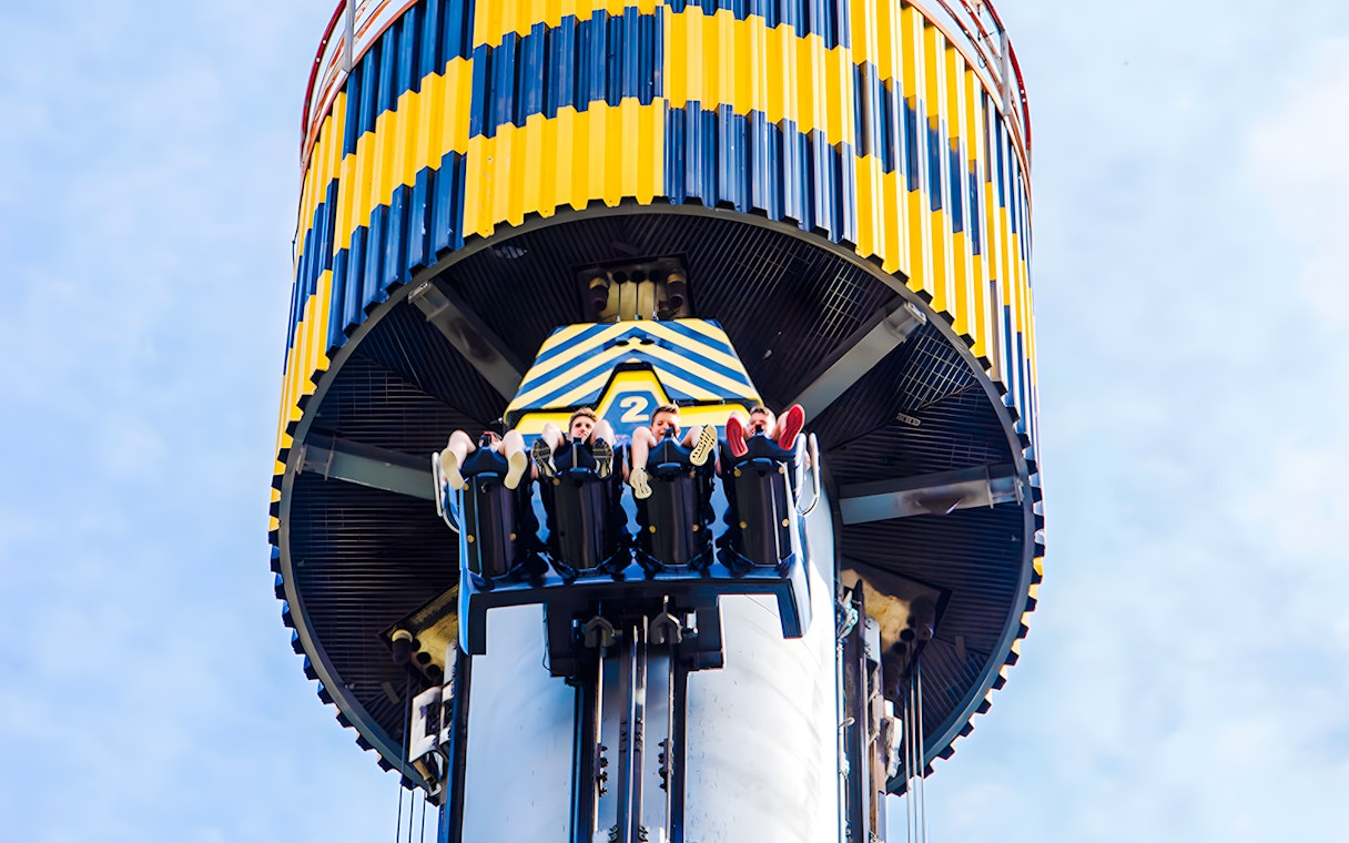 Riders on Lanzadera drop tower at Parque de Atracciones de Madrid.