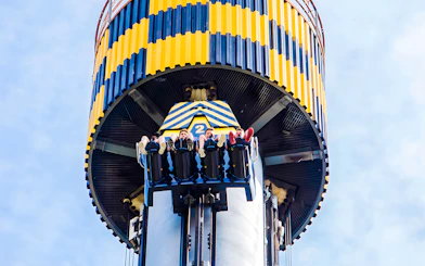 Riders on Lanzadera drop tower at Parque de Atracciones de Madrid.