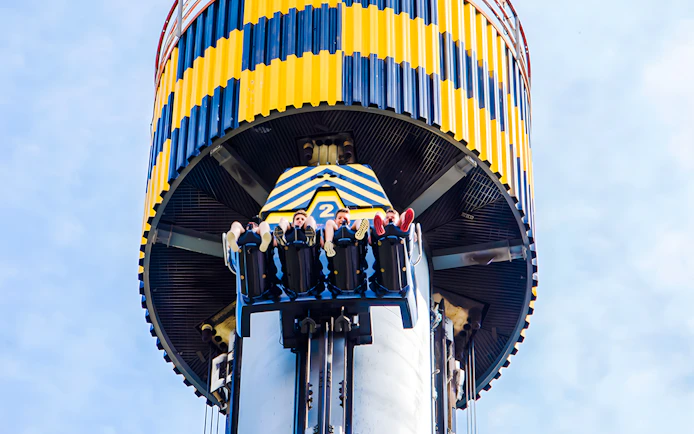Riders on Lanzadera drop tower at Parque de Atracciones de Madrid.