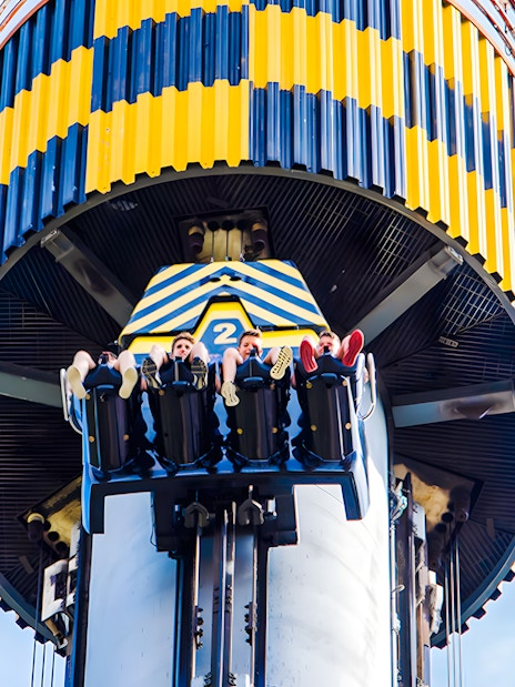 Riders on Lanzadera drop tower at Parque de Atracciones de Madrid.