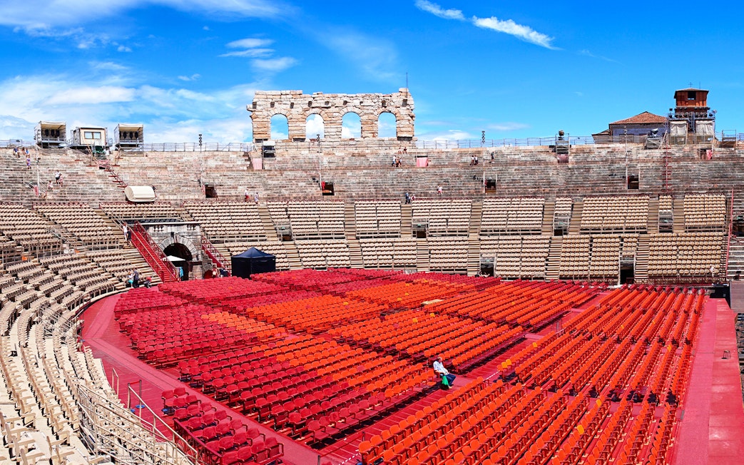 Verona Arena Italy with tourists exploring ancient Roman amphitheater architecture.