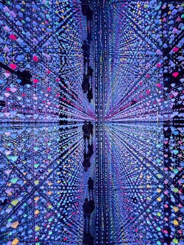 Colorful light installation at Moco Museum Barcelona with mirrored reflections.