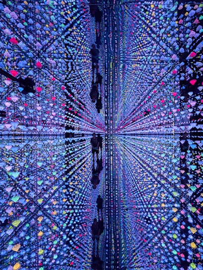 Colorful light installation at Moco Museum Barcelona with mirrored reflections.