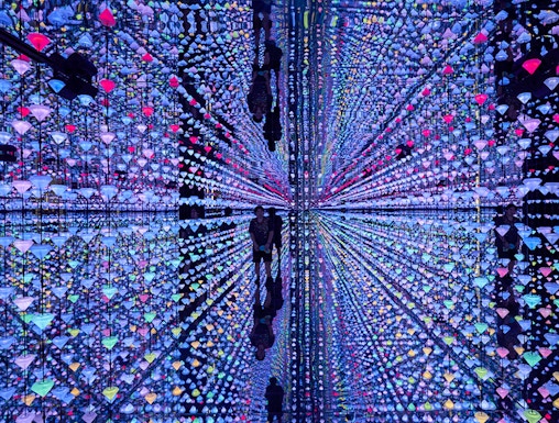 Colorful light installation at Moco Museum Barcelona with mirrored reflections.