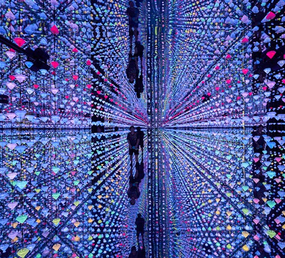 Colorful light installation at Moco Museum Barcelona with mirrored reflections.