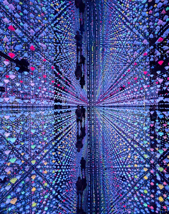 Colorful light installation at Moco Museum Barcelona with mirrored reflections.