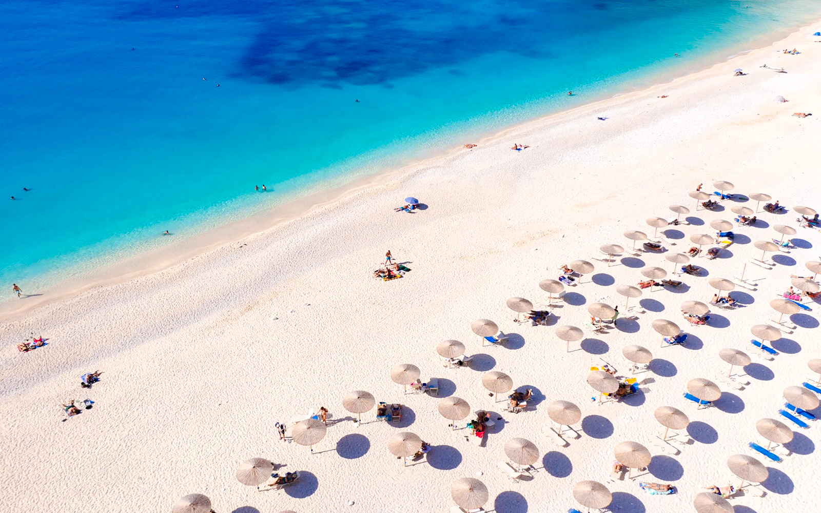 Sun umbrellas and loungers on Assos Beach, Kefalonia Island, Greece.