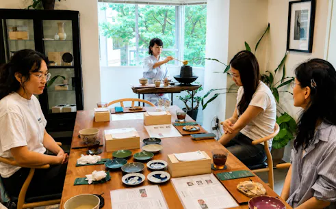 Kintsugi workshop participants with matcha and sweets near Shibuya Crossing.