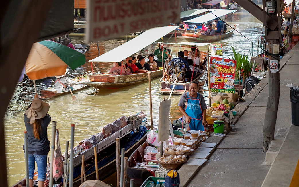 Boats and vendors at Amphawa Floating Market, Thailand.