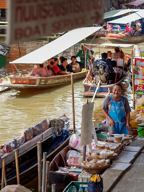 Boats and vendors at Amphawa Floating Market, Thailand.