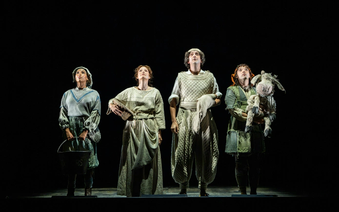 Four actors in medieval costumes on stage during "Into the Woods" performance.