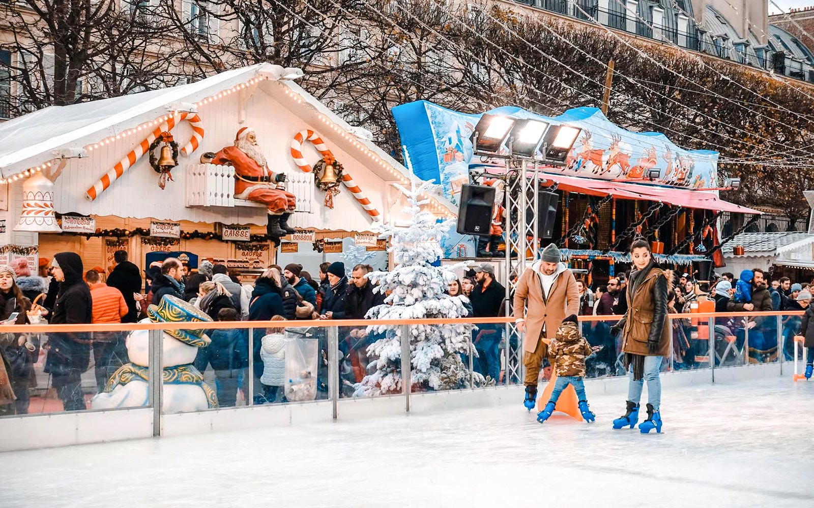 Ice skating at Paris Christmas Market with festive stalls and decorations.