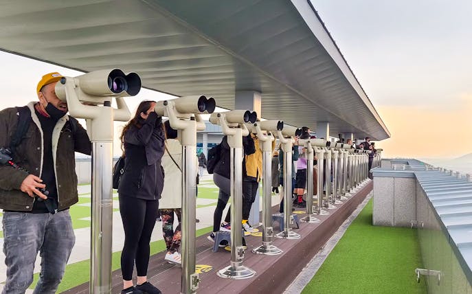 Visitors using telescopes at DMZ observation deck during full-day tour.