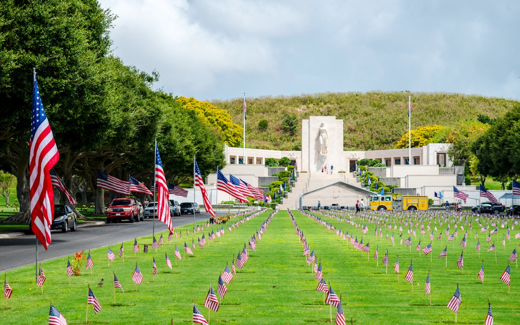 Aerial view of Punchbowl National Memorial Cemetery with American flags in Honolulu, Hawaii.