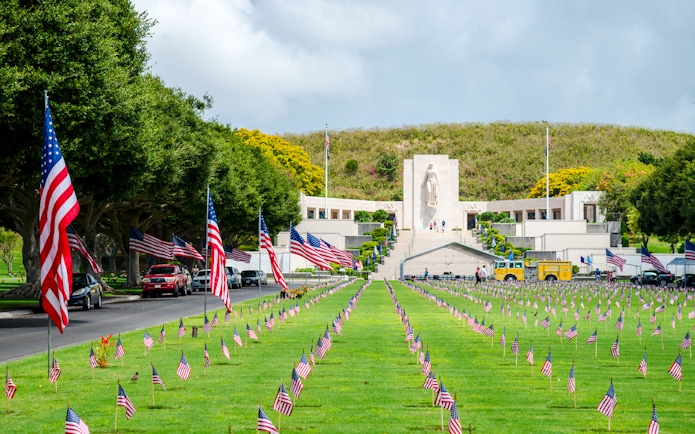 Aerial view of Punchbowl National Memorial Cemetery with American flags in Honolulu, Hawaii.