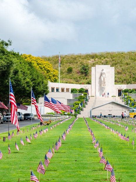 Aerial view of Punchbowl National Memorial Cemetery with American flags in Honolulu, Hawaii.
