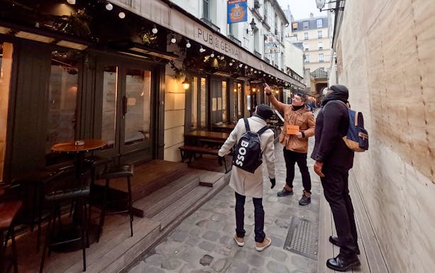 Tour guide showing Emily in Paris filming location at Pub St Germain, Paris.