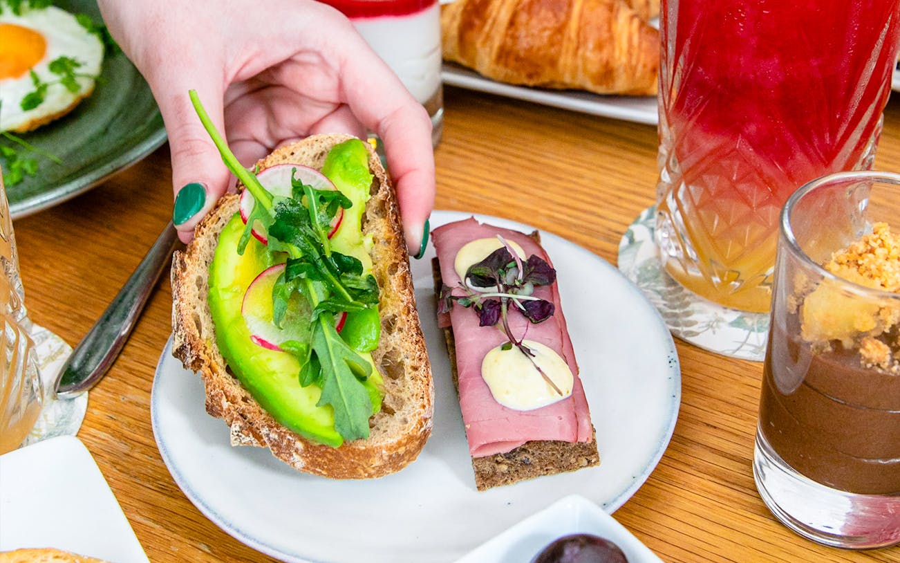 Avocado toast and cured meat on a plate at Flora Danica, Champs Elysées, Paris brunch.