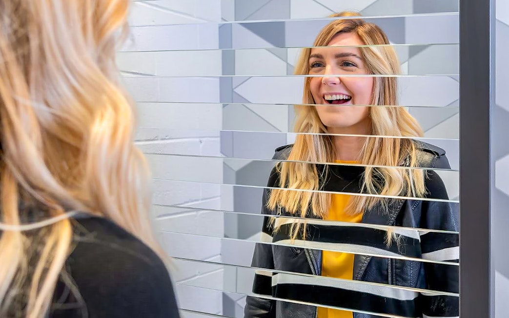 Visitor interacting with mirror illusion at Museum of Illusions Dubai.
