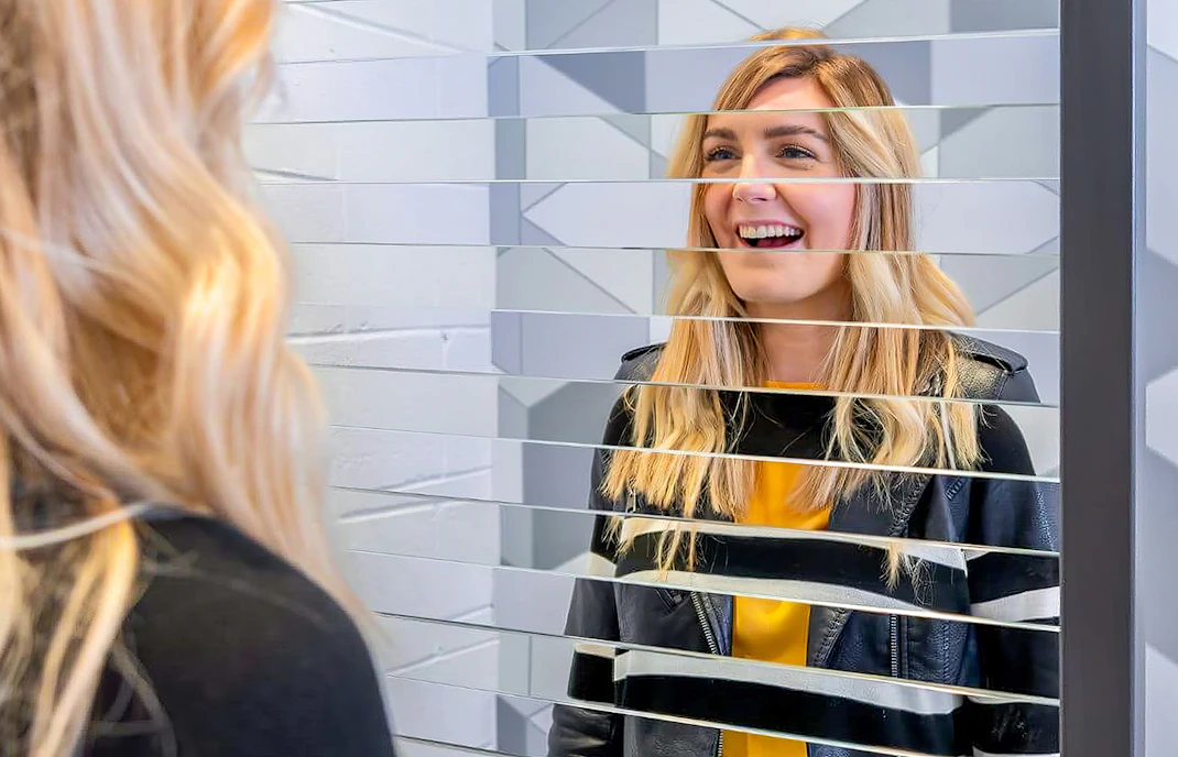 Visitor interacting with mirror illusion at Museum of Illusions Dubai.