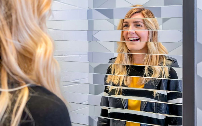 Visitor interacting with mirror illusion at Museum of Illusions Dubai.