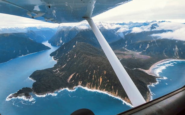 Aerial view of Milford Sound fjord and coastline from a plane during a scenic flyover tour from Queenstown.