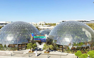 Butterfly Gardens Abu Dhabi glass domes with entrance and butterfly sculpture.