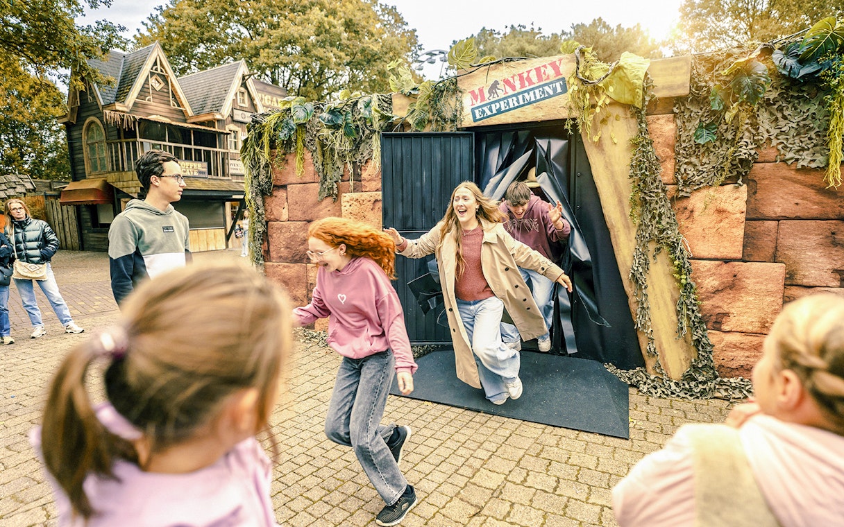Visitors exiting haunted house attraction at Bobbejaanland during Halloween event.