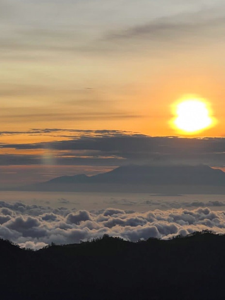 Sunrise view from Mount Batur with clouds and distant mountains in Bali.