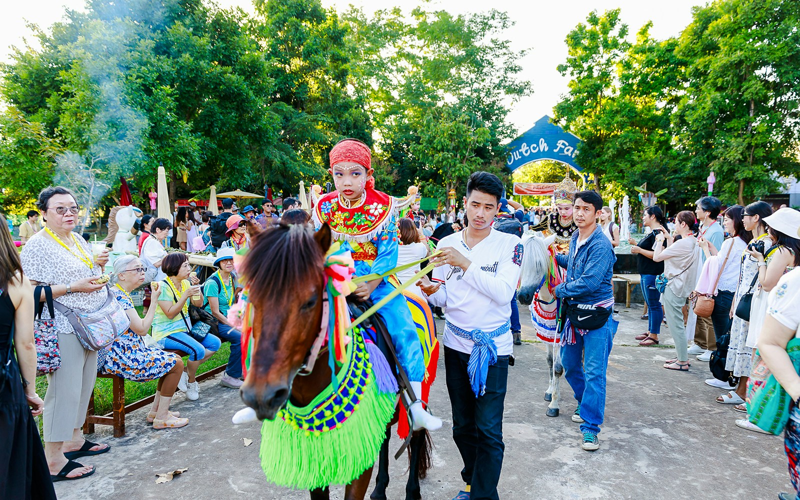 Young boy in traditional attire on a decorated horse at Chiang Mai Sky Lanterns Festival parade.