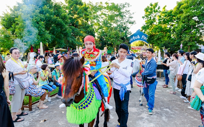 Young boy in traditional attire on a decorated horse at Chiang Mai Sky Lanterns Festival parade.