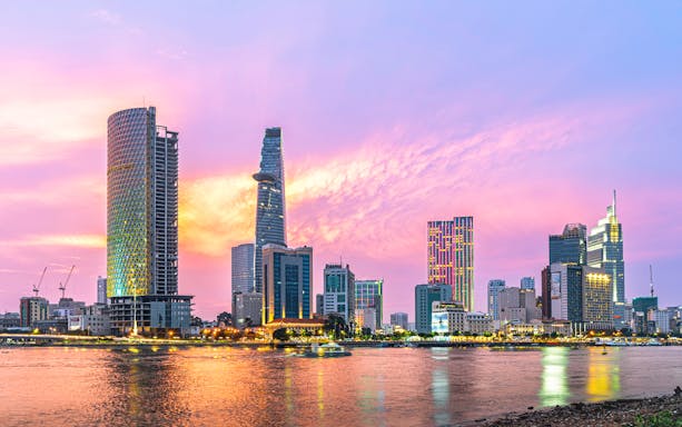 Cityscape of Ho Chi Minh City with Saigon River at sunset.